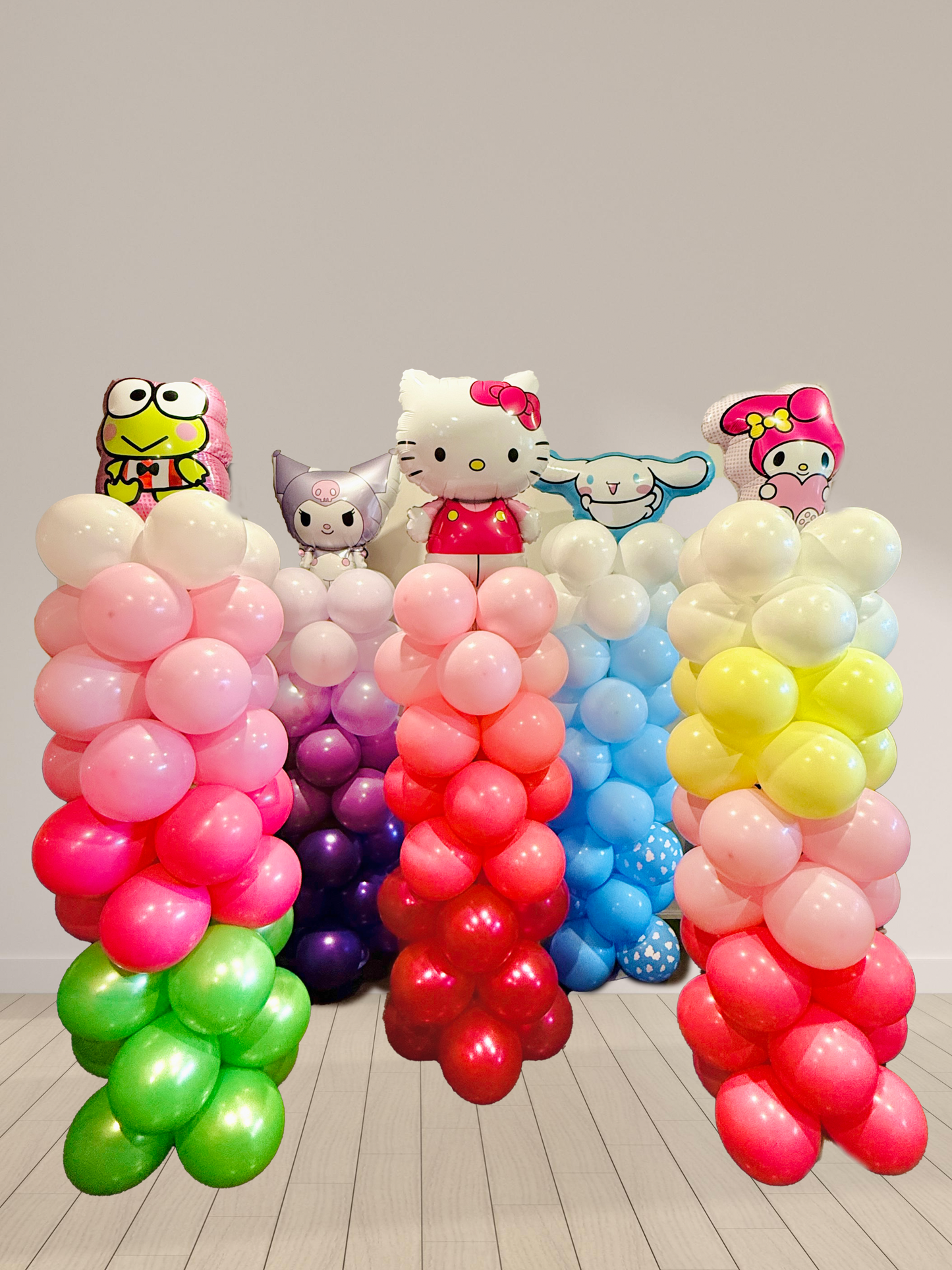 Colorful balloon arch with cartoon character heads on a plain background
