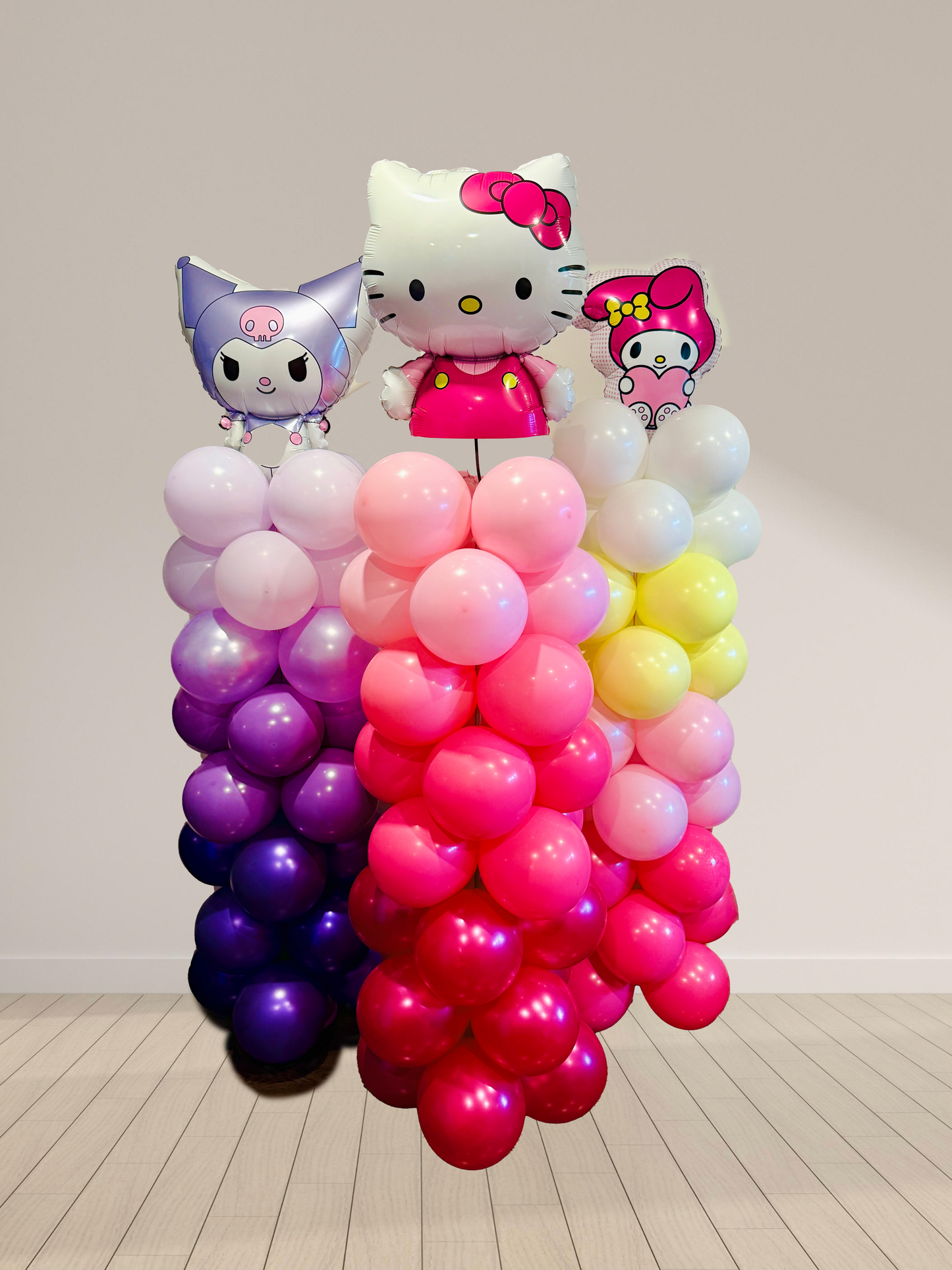 Colorful balloon display with cartoon character figures on a plain background