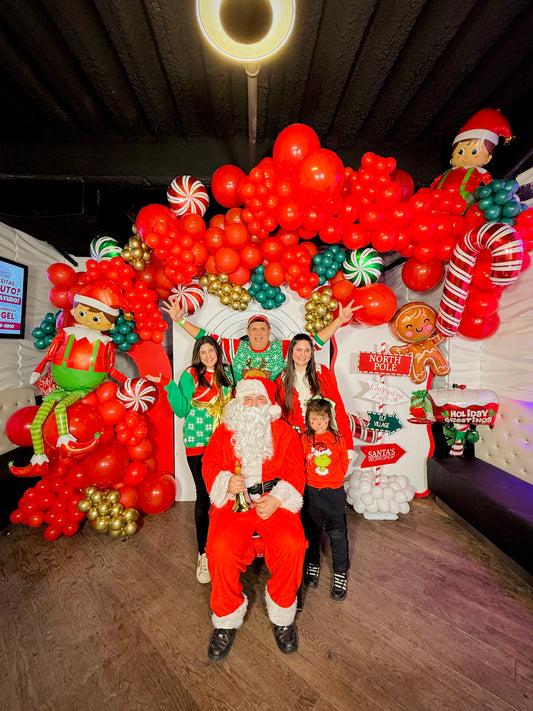 Christmas balloon decoration with elf balloons, candy cane props, and festive balloon garlands.