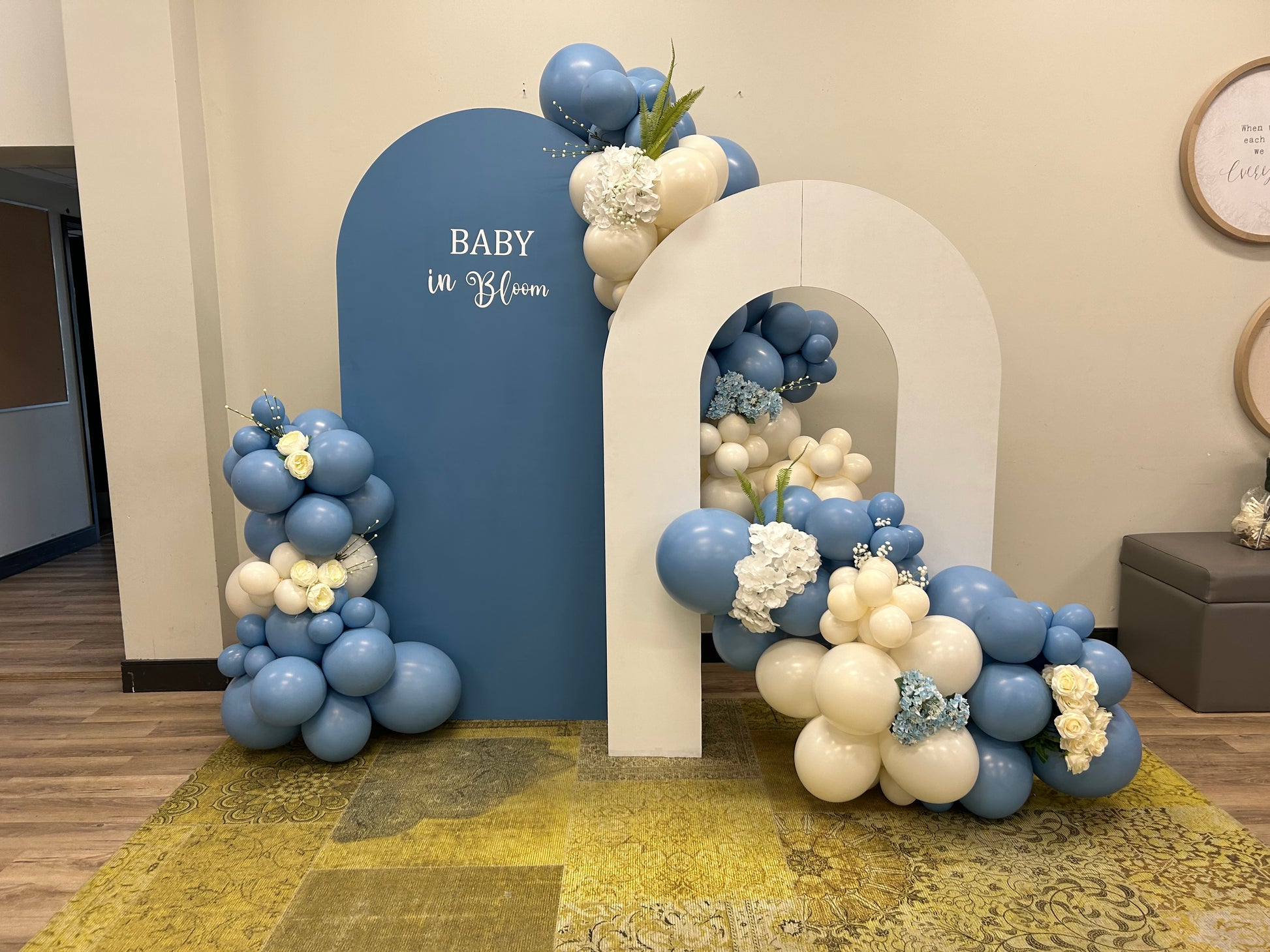 Baby in Bloom Balloon Setup with blue and ivory balloons, floral accents, and greenery