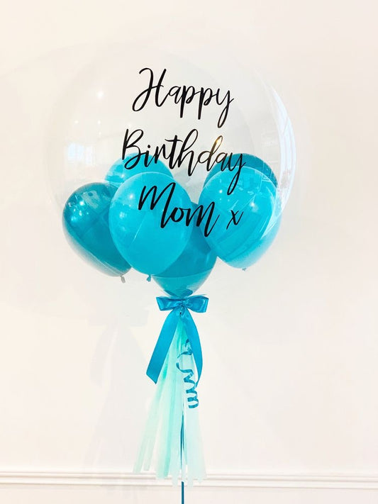 Clear Bubble Balloon with custom message, helium-filled, with mini balloons, confetti, or petals inside, including a tassel, bow, and balloon weight.
