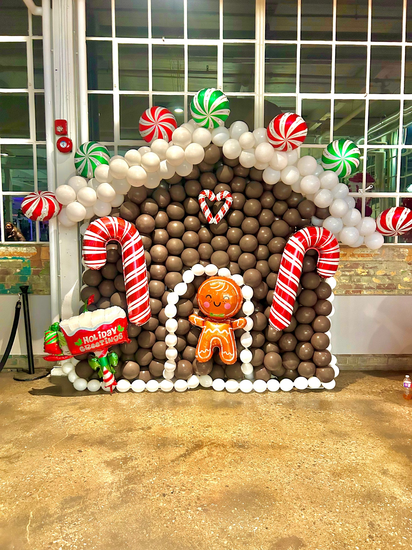 Christmas Balloon Numbers and Light Stands Decor with festive candy cane accents and gingerbread house backdrop.