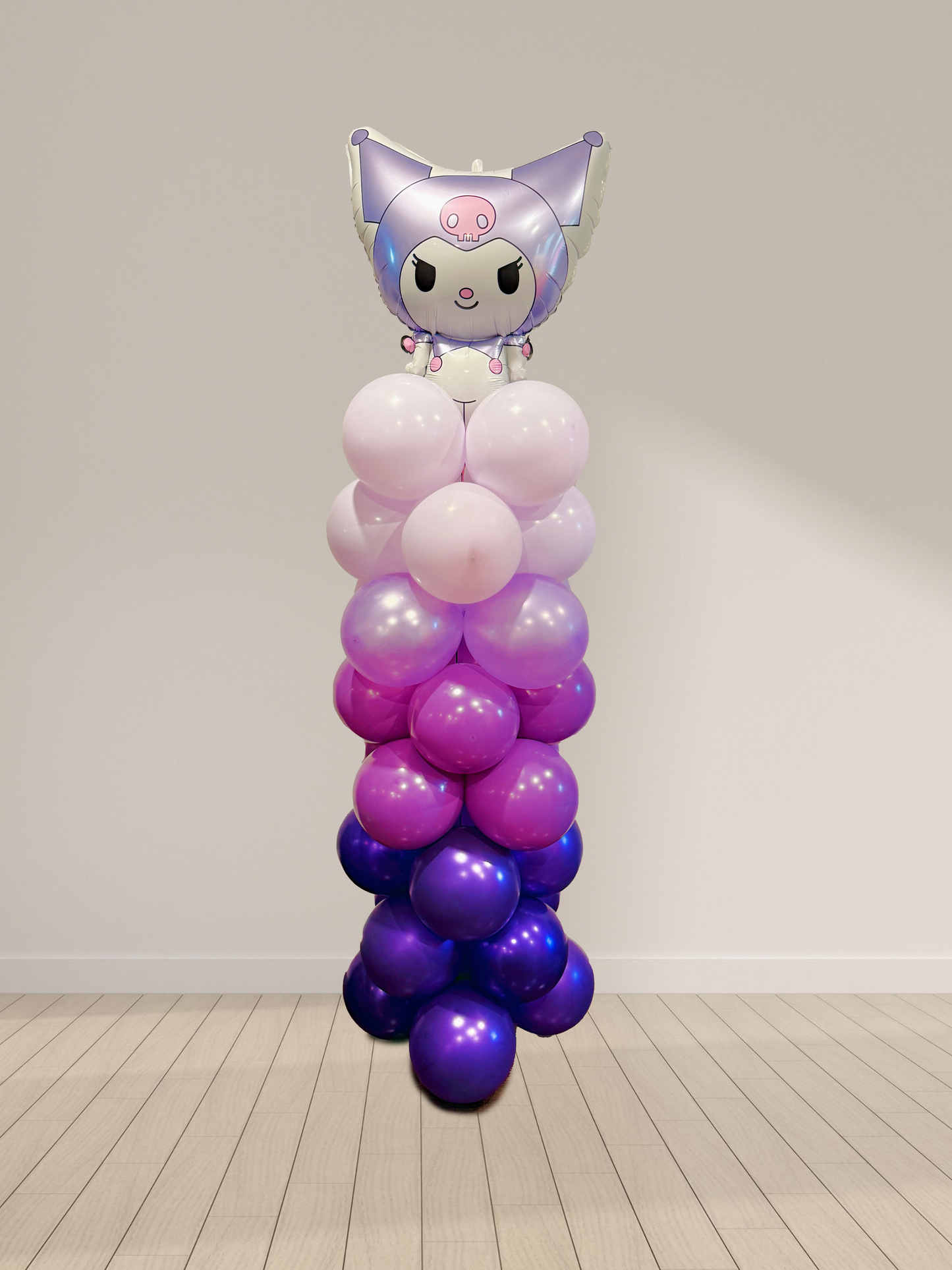 Balloon sculpture with a character on top against a plain background
