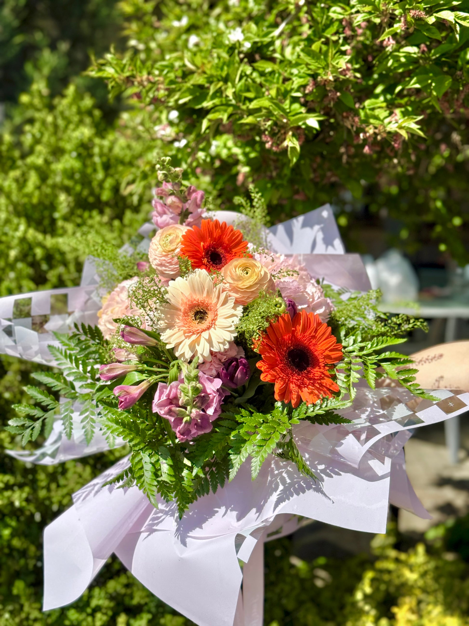 Bouquet of flowers with orange and yellow colors wrapped in white paper.