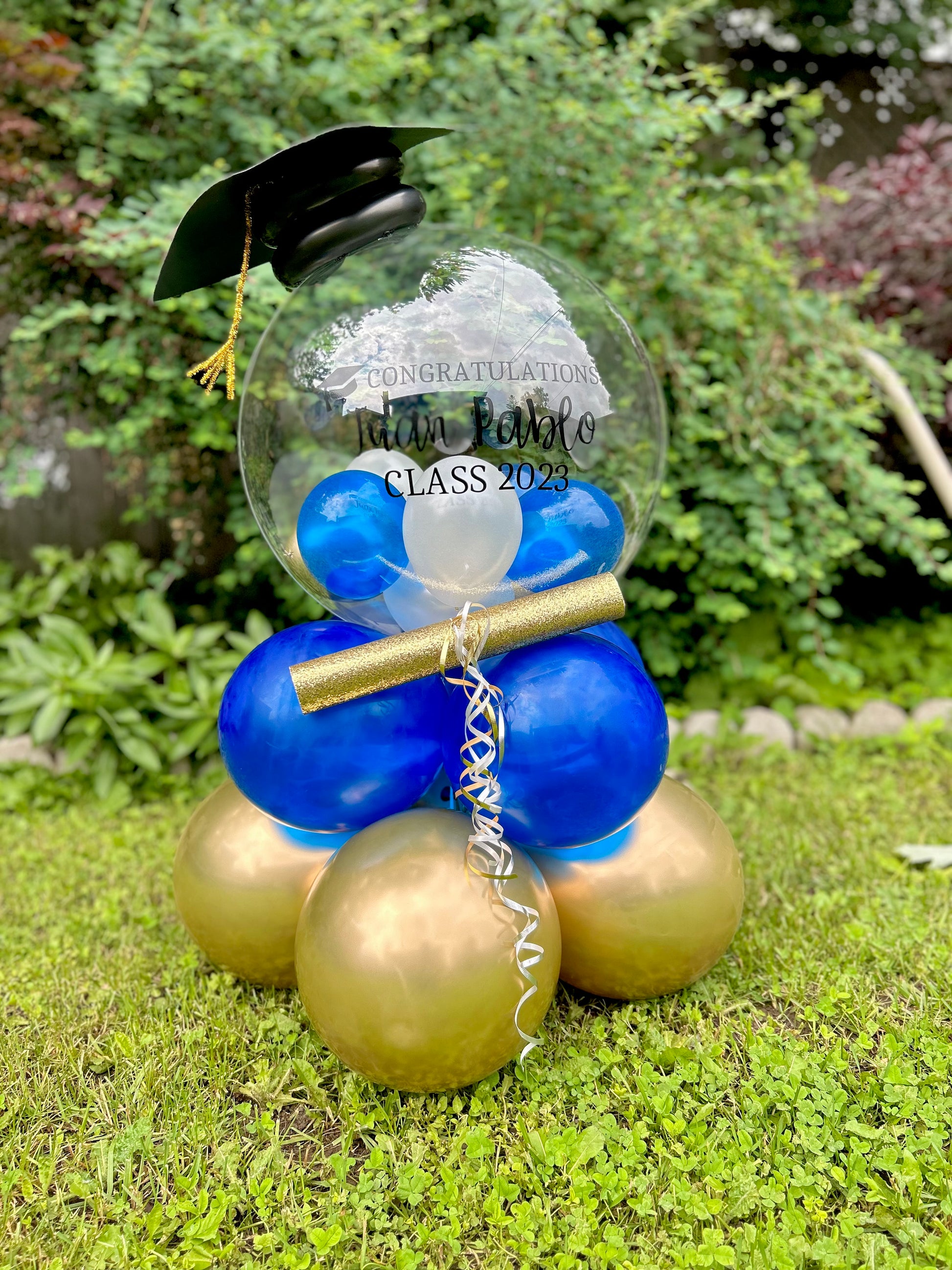 Graduation Balloon Gift with clear bobo balloon, mini balloons, diploma, and grad cap decoration.