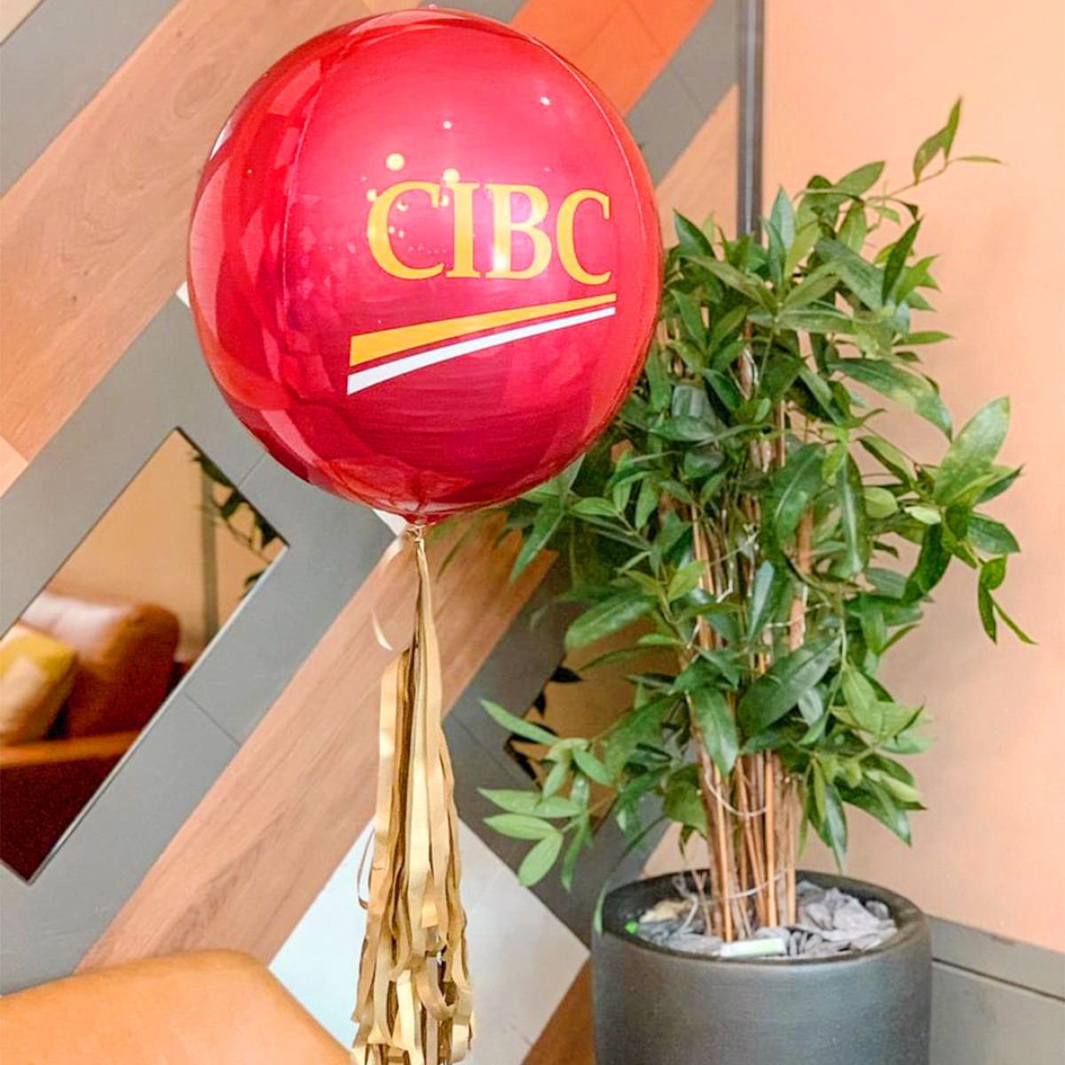 Branded Metallic Orbz Balloon with Tassel Tail featuring a custom logo and vibrant tassel in matching brand colors.