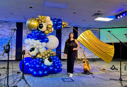 Luxury Soccer Balloon Backdrop with a gold arch, blue and white balloon arrangement, and soccer-themed decorations for a sports event.