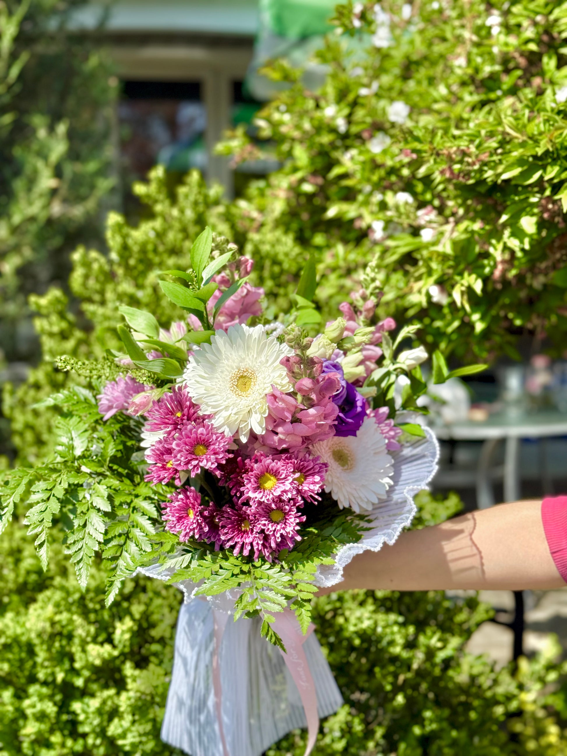 Bouquet of flowers held in front of a green background