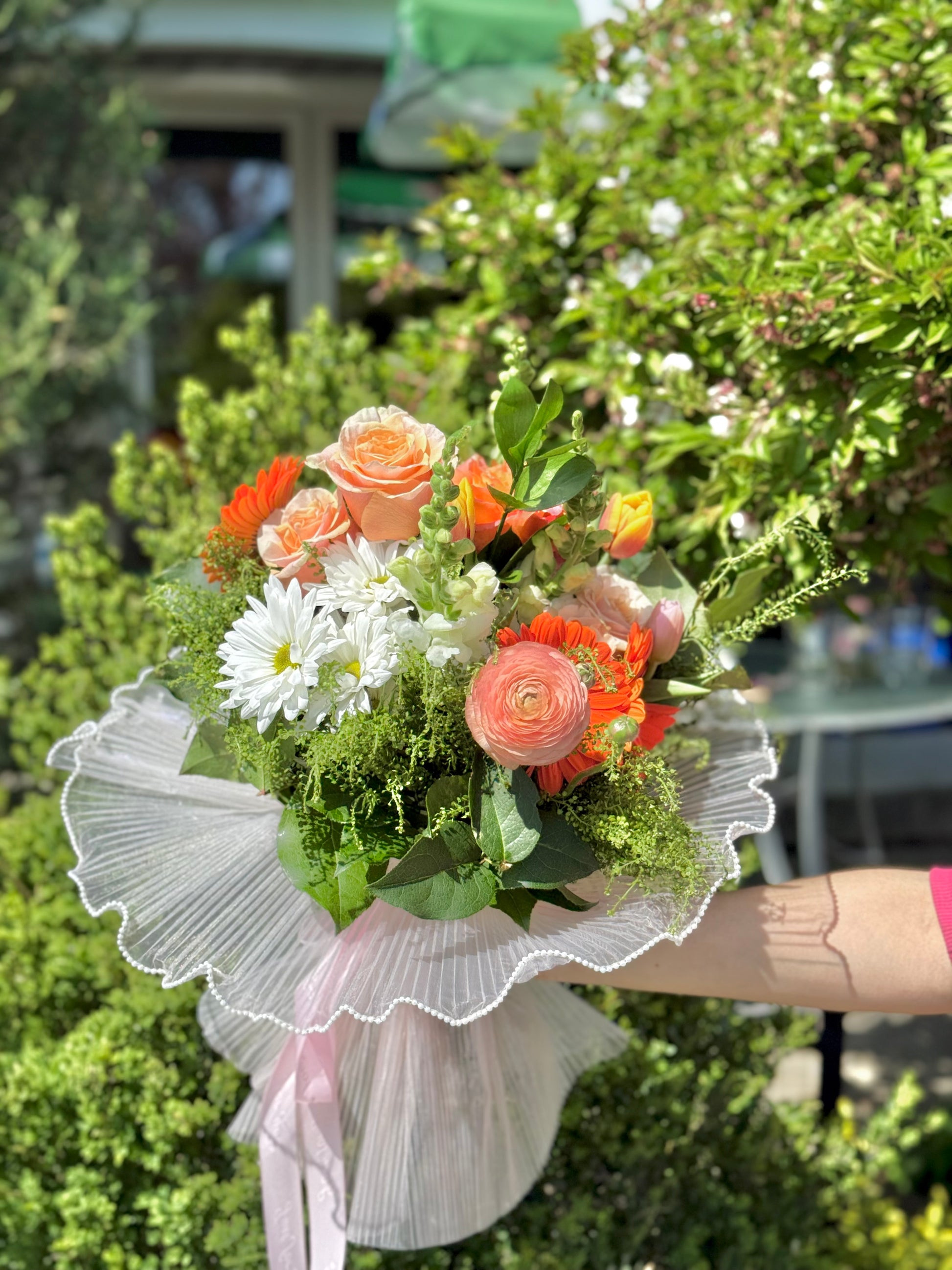 Bouquet of flowers with orange roses and white daisies.