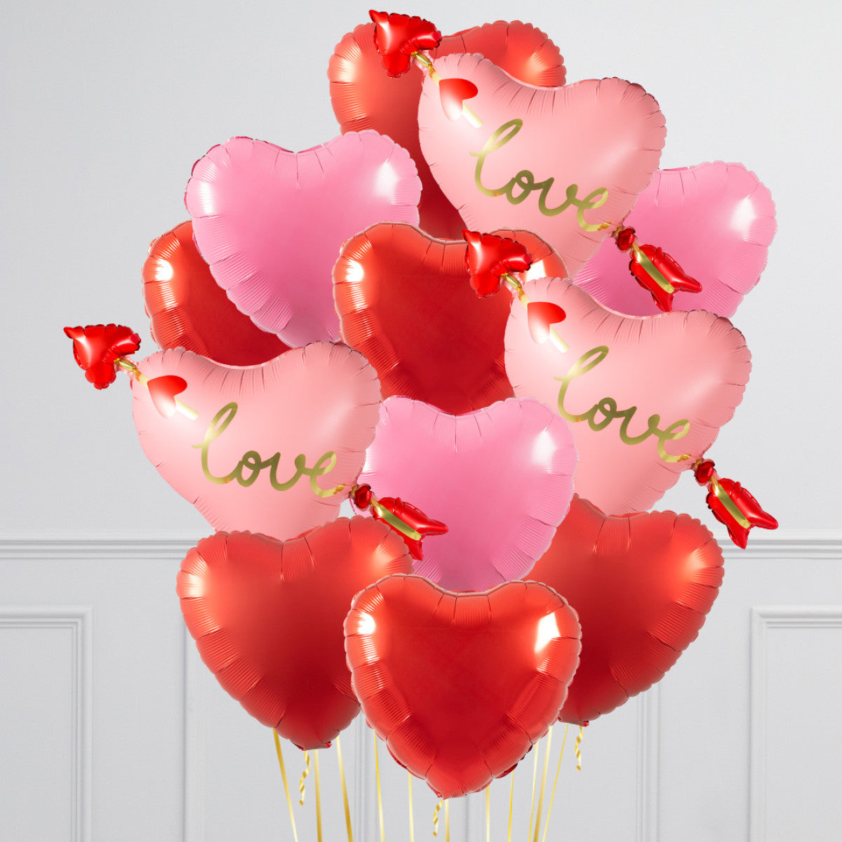 A dozen 17-inch heart-shaped foil balloons, helium-filled with a balloon weight.