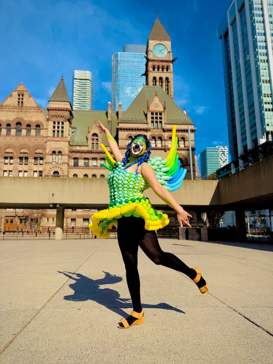 Balloon artist modeling a custom winged balloon dress at Nathan Phillips Square in downtown Toronto