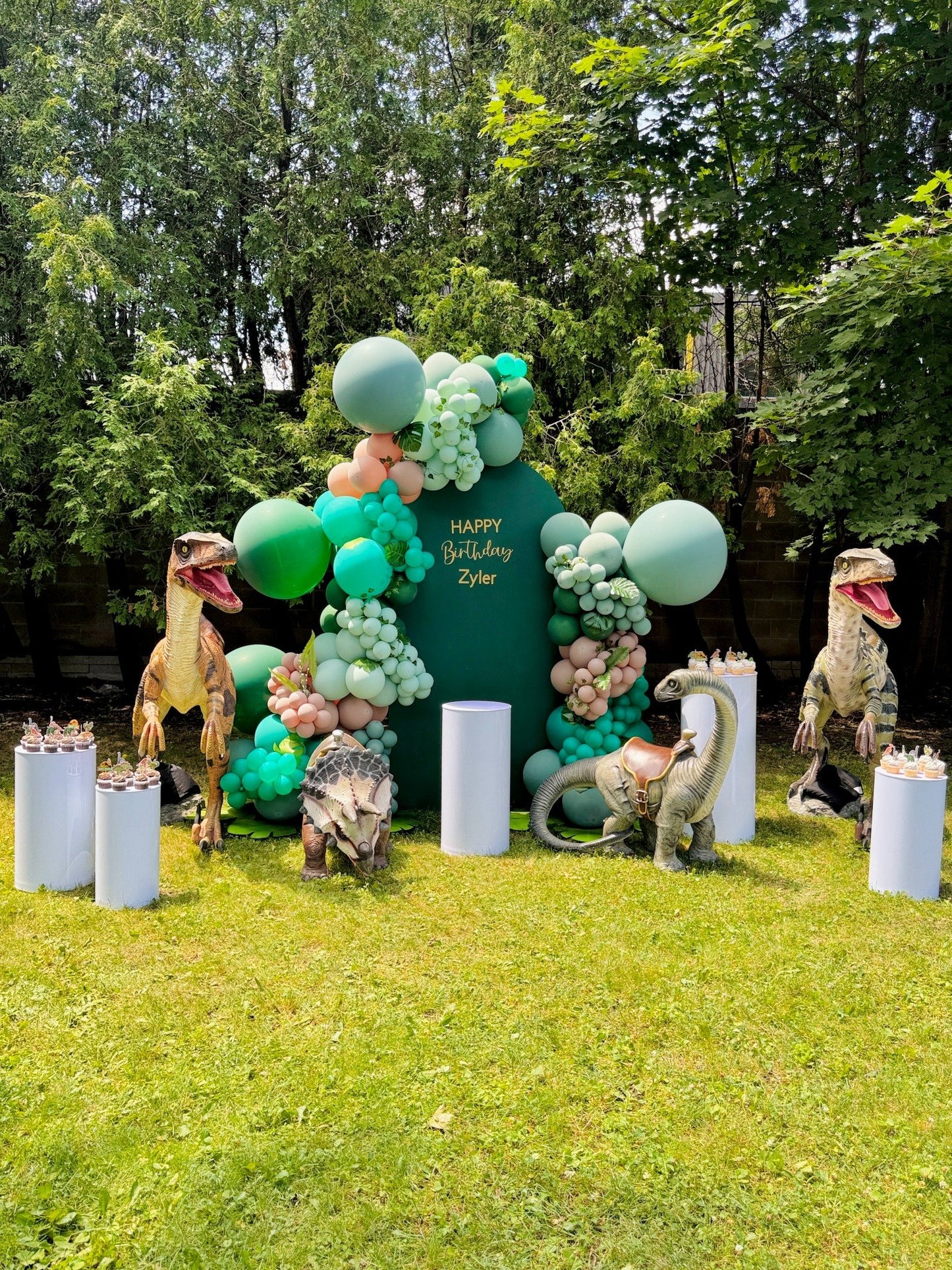 Jurassic balloon birthday setup with green backdrop and dinosaurs – Wooow Balloons Toronto