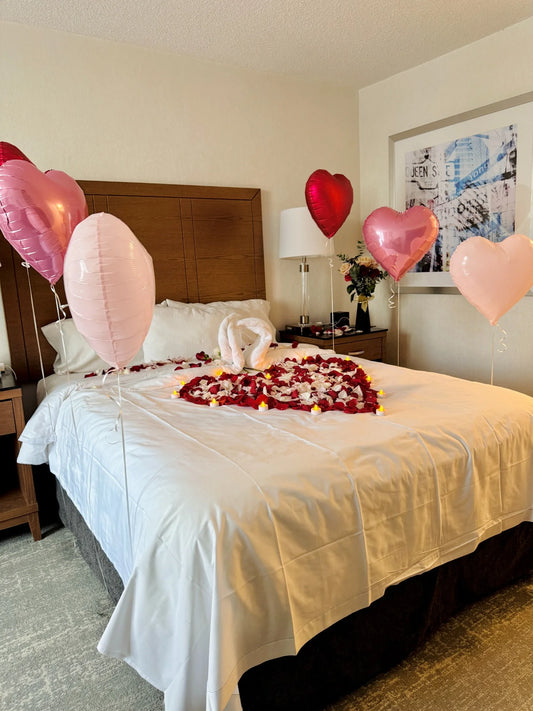 Romantic bed decoration with heart balloons, petals, and LED candles – perfect for anniversaries in Toronto