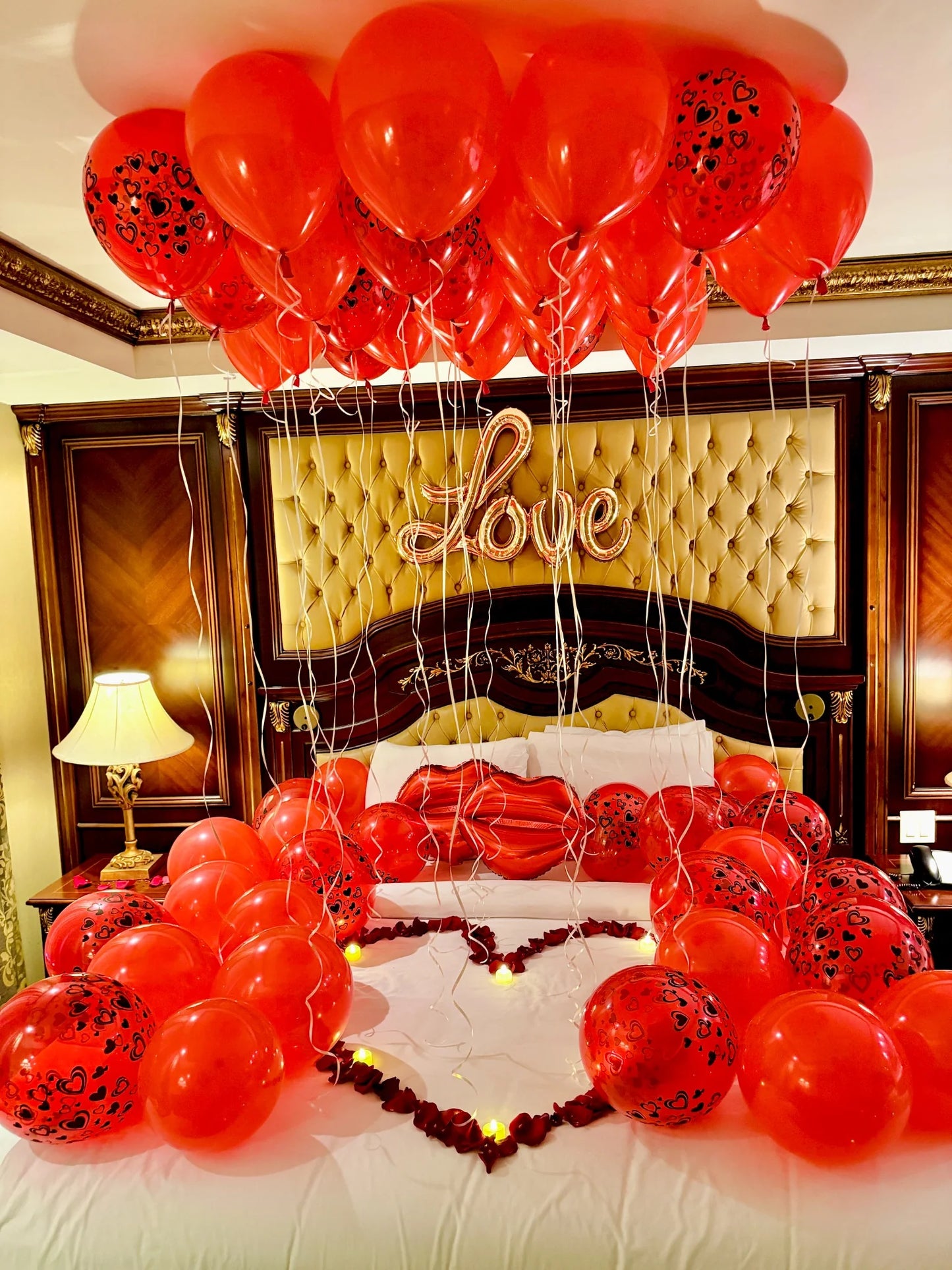 Hotel room decorated for a romantic surprise with heart balloons and candles in Toronto.