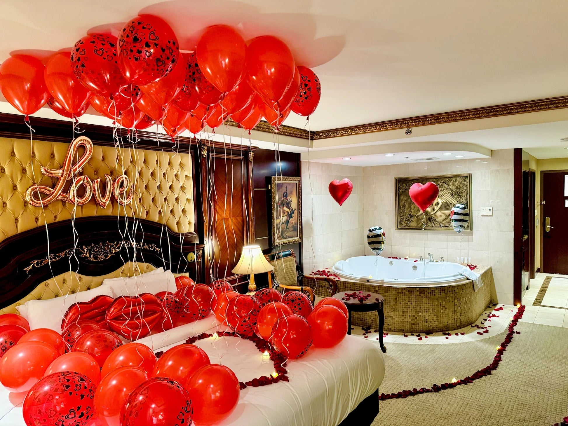 Rose petals pathway and red balloons leading to a luxury bed – romantic experience by Wooow Balloons Toronto