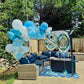 Outdoor setting with blue and white balloons and a '80' balloon in a garden.