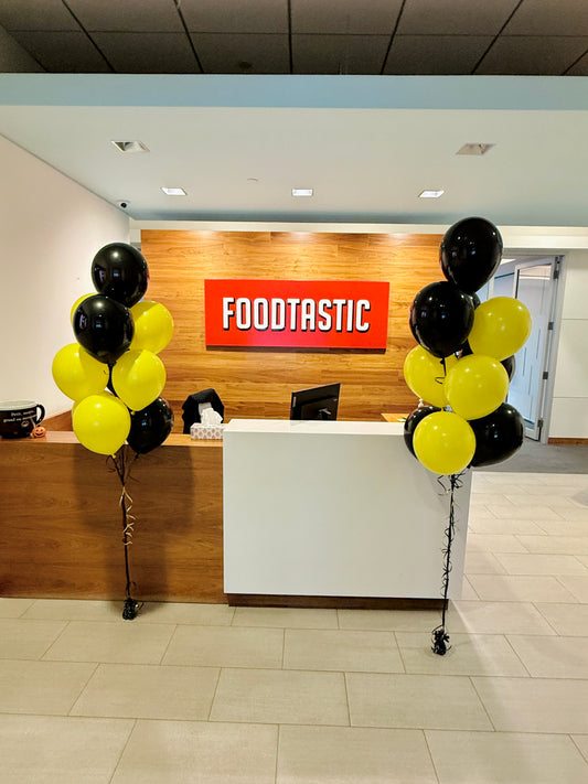 Front desk area with 'Foodtastic' sign and balloons in a modern office setting