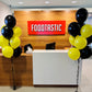 Front desk area with 'FOODTASTIC' sign and balloons in a modern interior setting