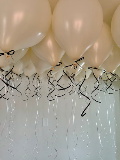 Coquette Balloons with helium-filled biodegradable balloons and decorative bows.

