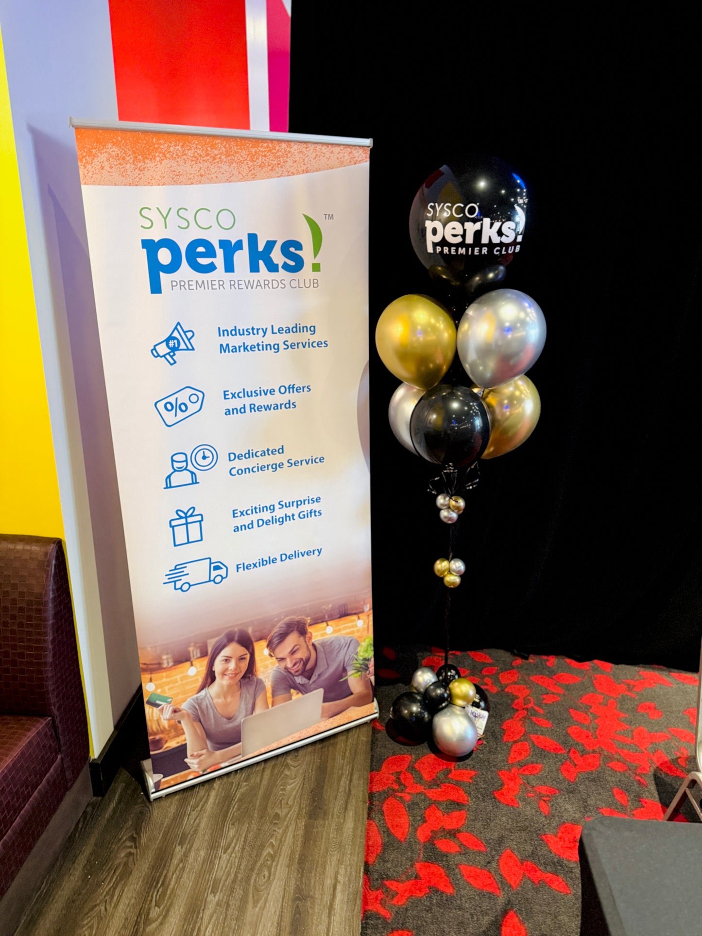 SYSCO Perks banner with balloons on a carpeted floor
