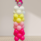 Balloon column with a character balloon on top against a plain wall.