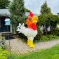 Balloon sculpture of a rooster in a garden setting