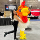 Person posing with a large balloon rooster at an event.