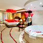 Decorative bedroom with balloons, rose petals, and a bathtub.