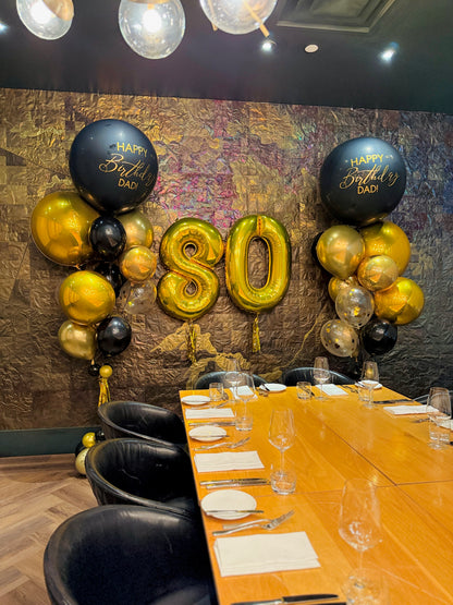 Decorated room with 'Happy Birthday Dad' balloons and a table set for a celebration.