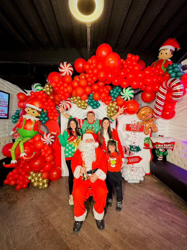  Christmas balloon decoration with elf balloons, candy cane props, and festive balloon garlands.