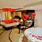 Decorative bedroom with heart-shaped balloons, rose petals, and a bathtub.