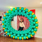 Giant Christmas Balloon Wreath made with biodegradable balloons, customizable design, 10ft size with a red or gold bow.
