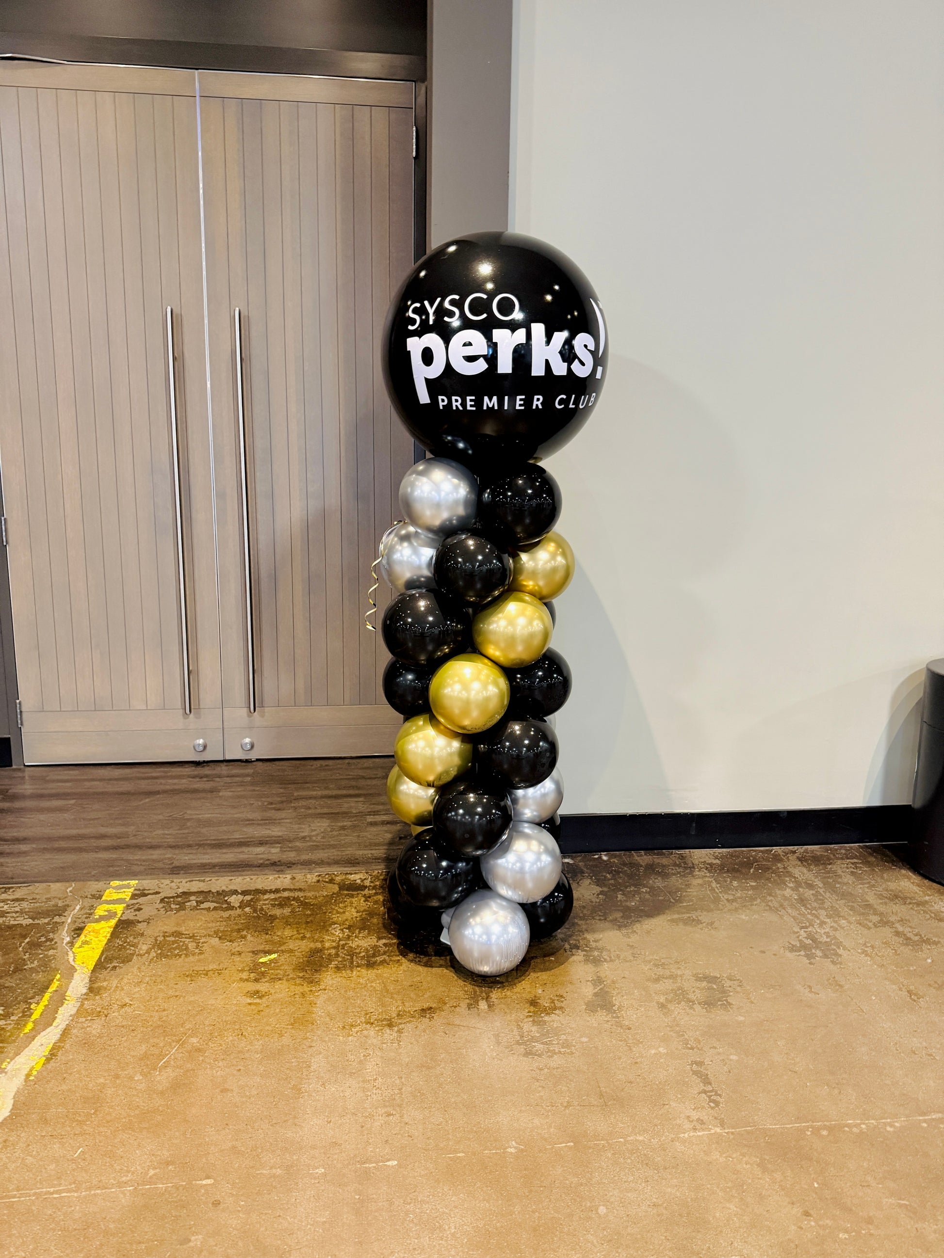 Balloon column with Sysco Perks logo in a room setting