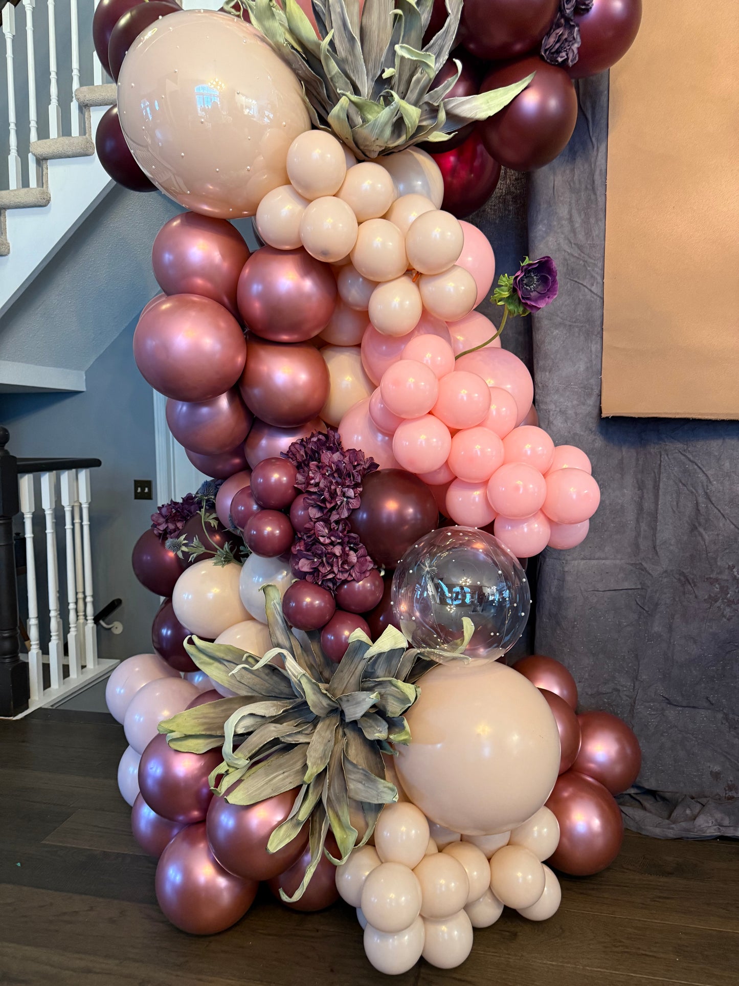 Luxury spring floral balloon garland with blush, gold, and greenery for elegant event decor.