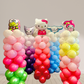 Colorful balloon arch with cartoon character heads on a plain background
