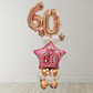 Balloon arrangement with '60' on a star-shaped balloon against a white wall.