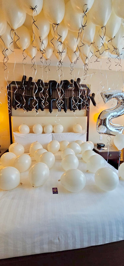 Birthday Celebration Room Setup Toronto Creamy Blush Birthday Room Decor with helium balloons, banner, and number stands.