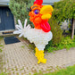 Balloon sculpture of a rooster in front of a house