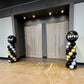 Balloon arches with 'SYSC Perks' branding in a room with white walls and a concrete floor.