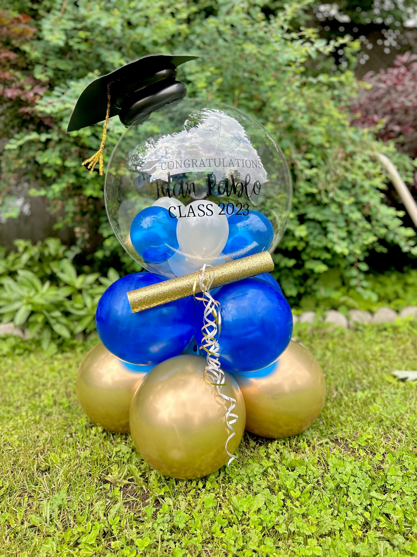 Graduation Balloon Gift with clear bobo balloon, mini balloons, diploma, and grad cap decoration.