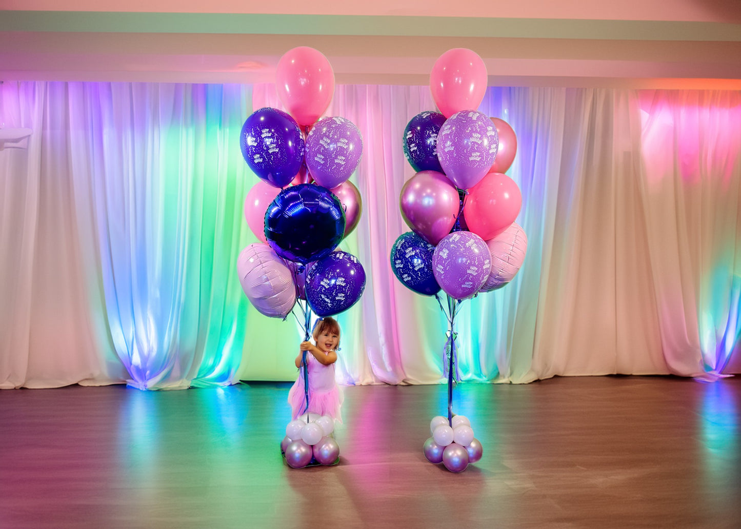 Birthday Balloon Bouquets Toronto – Pink and purple helium balloons with a cute baby at a colorful party setup by Wooow Balloons Toronto.