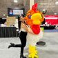 Woman posing with a large balloon rooster at an event.