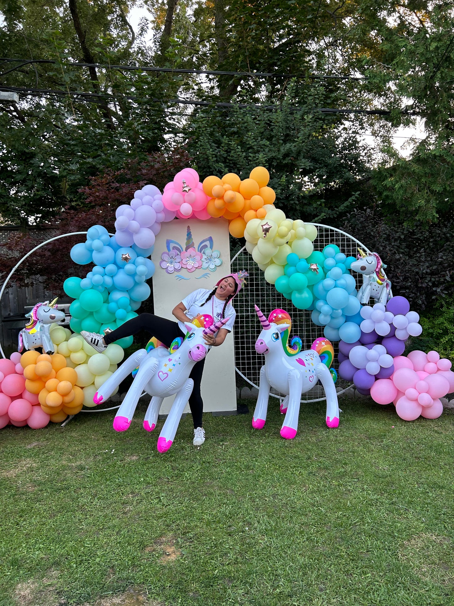 Magical Unicorn Balloon Backdrop with a pastel rainbow balloon arch and inflatable unicorn decorations for a kids’ party.