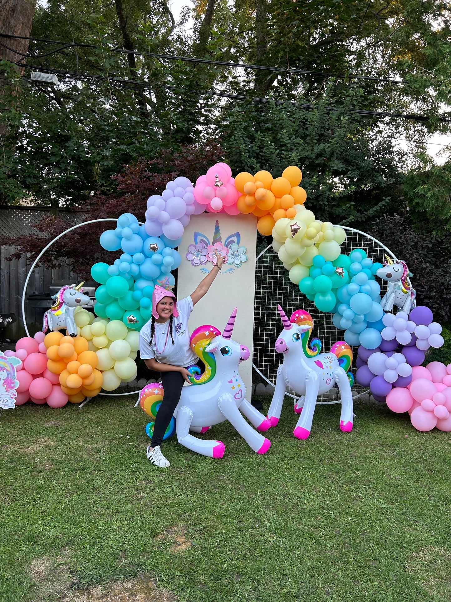 Magical Unicorn Balloon Backdrop with a pastel rainbow balloon arch and inflatable unicorn decorations for a kids’ party.