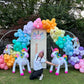 Magical Unicorn Balloon Backdrop with a pastel rainbow balloon arch and inflatable unicorn decorations for a kids’ party.