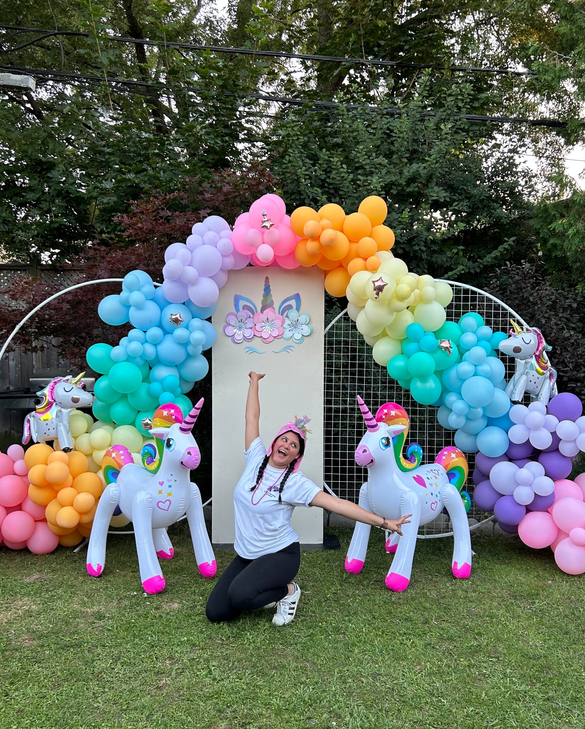 Magical Unicorn Balloon Backdrop with a pastel rainbow balloon arch and inflatable unicorn decorations for a kids’ party.