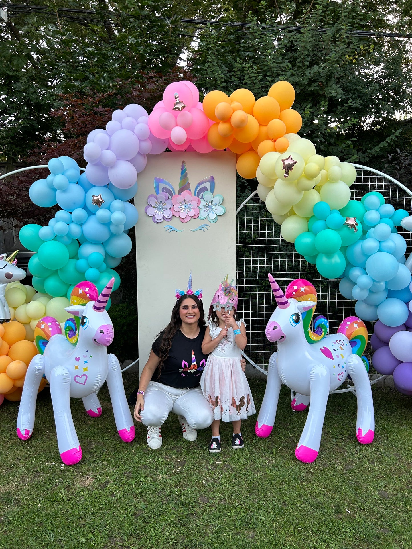 Magical Unicorn Balloon Backdrop with a pastel rainbow balloon arch and inflatable unicorn decorations for a kids’ party.