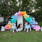 Magical Unicorn Balloon Backdrop with a pastel rainbow balloon arch and inflatable unicorn decorations for a kids’ party.