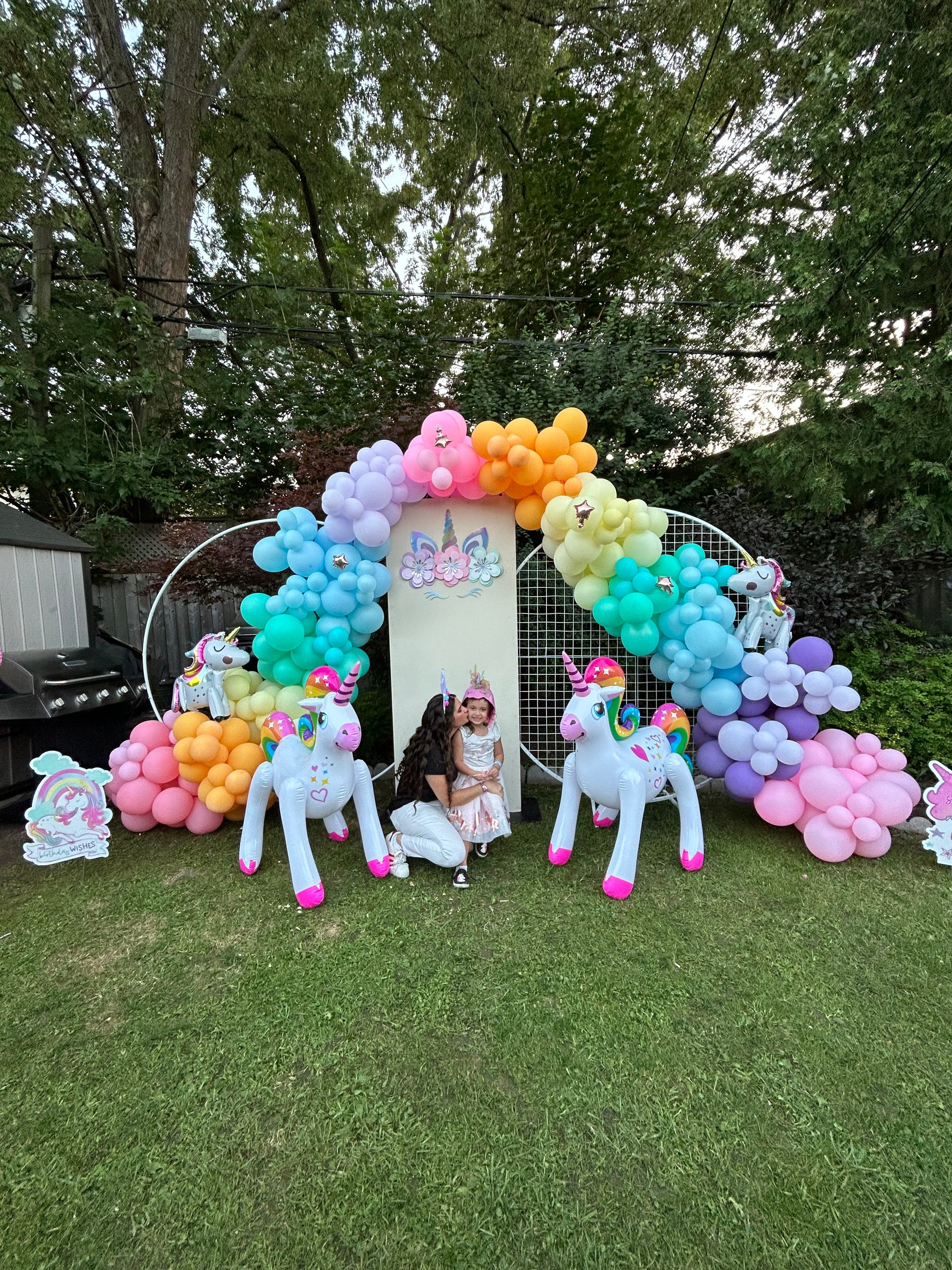 Magical Unicorn Balloon Backdrop with a pastel rainbow balloon arch and inflatable unicorn decorations for a kids’ party.