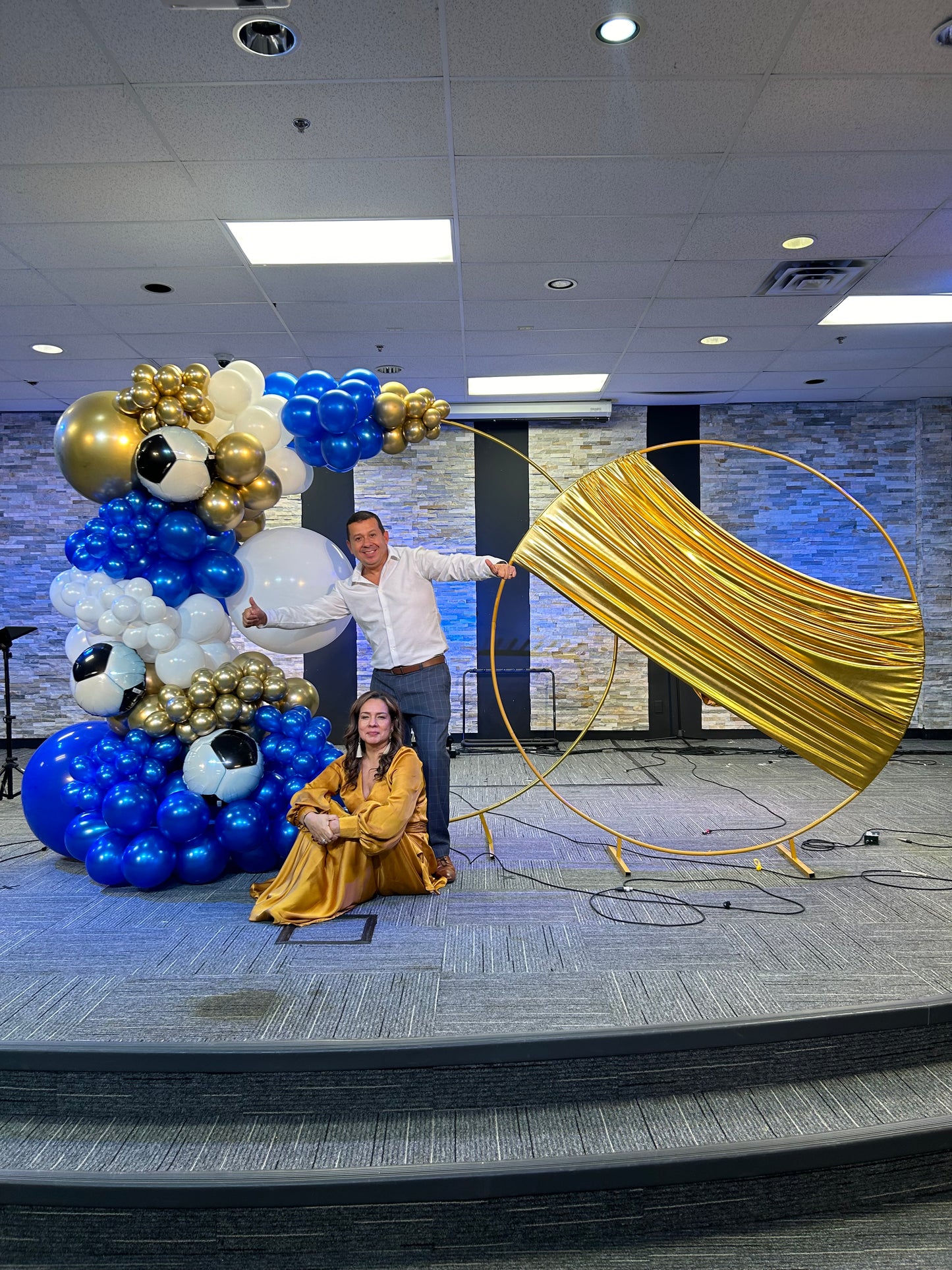 Luxury Soccer Balloon Backdrop with a gold arch, blue and white balloon arrangement, and soccer-themed decorations for a sports event.